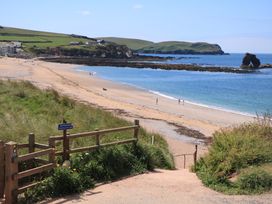 A beach with people walking along the shoreline at Savernake in Thurlestone