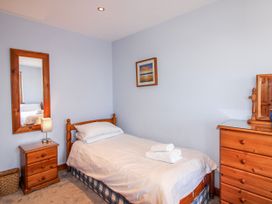 A bedroom with a single bed and wooden furniture at The Station in Bolberry