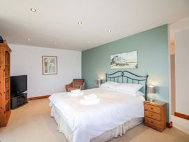 A bedroom with a bed, tv, and chair at The Station in Bolberry