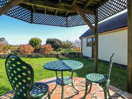 A garden with a table and chairs under a pergola at The Station in Bolberry