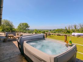 An outdoor space with a hot tub and table at Mellydonen Beder Del (Melly), Tor Down Quarry, St Breward
