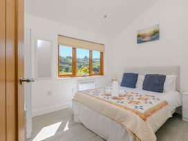 A bedroom with a bed and window view at Mellydonen Beder Del (Melly), Tor Down Quarry, St Breward