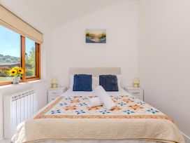 A bedroom with a bed and quilt at Mellydonen Beder Del (Melly), Tor Down Quarry in St Breward