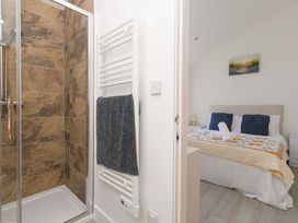 A bathroom with a shower and a view of a bedroom at Mellydonen Beder Del (Melly), Tor Down Quarry in St Breward