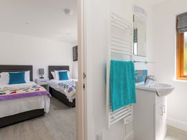 A bedroom with two beds and a bathroom sink at Mellydonen Beder Del (Melly), Tor Down Quarry St Breward