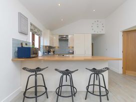 A kitchen with bar stools and appliances at Mellydonen Beder Del (Melly), Tor Down Quarry in St Breward