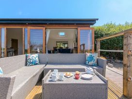 An outdoor seating area with a sofa and coffee table at Mellydonen Beder Del (Melly), Tor Down Quarry St Breward