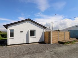 A house with a wooden fence and gravel pathway at Maes Y Coed in Morfa Nefyn