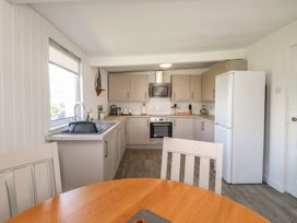A kitchen with cabinets and appliances at Maes Y Coed in Morfa Nefyn