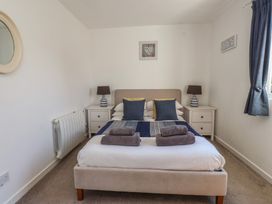 A bedroom with a bed and nightstands at Maes Y Coed in Morfa Nefyn