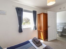 A bedroom with a wardrobe and window at Maes Y Coed in Morfa Nefyn