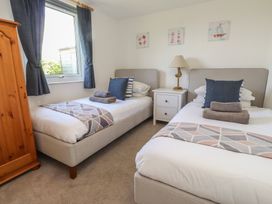 A bedroom with two beds and a nightstand at Maes Y Coed in Morfa Nefyn