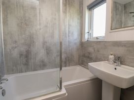 A bathroom with a bathtub and sink at Maes Y Coed in Morfa Nefyn