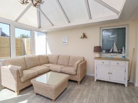 A conservatory with a sofa and coffee table at Maes Y Coed in Morfa Nefyn