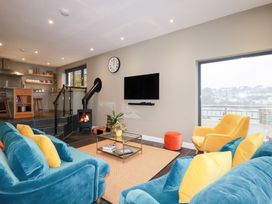 A living room with a sofa and fireplace at Postcard Lodge in Polruan