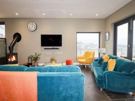 A living room with a sofa and armchair at Postcard Lodge in Polruan