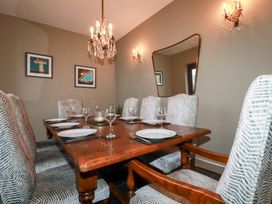 A dining room with a wooden table and chairs at Postcard Lodge in Polruan