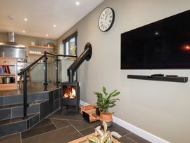 A kitchen with a fireplace and television at Postcard Lodge Polruan