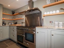 A kitchen with stainless steel appliances and cabinetry at Postcard Lodge Polruan