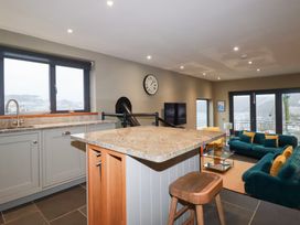 A kitchen with a countertop and sofa at Postcard Lodge in Polruan