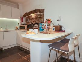 A kitchen with a coffee maker and bar stools at Rock House Trebarwith Strand near Tintagel
