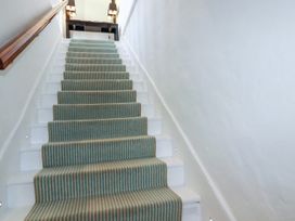 A staircase with carpet and light fixtures at Rock House Trebarwith Strand near Tintagel