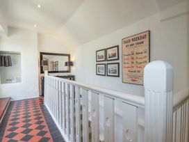 A hallway with pictures and a mirror at Rock House Trebarwith Strand near Tintagel