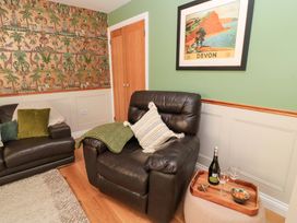 A living room with an armchair and a sofa at The Old Dairy in Cotleigh near Honiton