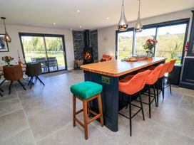 A kitchen with seating at the island and a fireplace at The Old Dairy in Cotleigh near Honiton