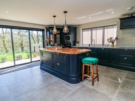 A kitchen with an island and stools at The Old Dairy Cotleigh near Honiton