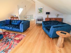 A living room with blue sofas and a coffee table at The Old Dairy near Honiton