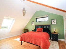 A bedroom with a bed and nightstands at The Old Dairy Cotleigh near Honiton