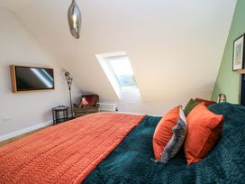 A bedroom with a bed and television at The Old Dairy Cotleigh near Honiton