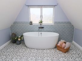 A bathroom with a bathtub and sink at The Old Dairy in Cotleigh near Honiton