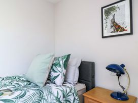 A bedroom with a bed, pillows, a bedside table and a lamp at The Old Dairy Cotleigh near Honiton