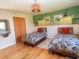 A bedroom with two beds and wall art at The Old Dairy Cotleigh near Honiton