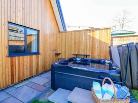 An outdoor area with a hot tub and wooden walls at The Old Dairy Cotleigh near Honiton