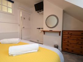 A bedroom with a bed and television at Saints Cottage in Scarborough