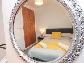 A bedroom with a bed and a wardrobe at Saints Cottage in Scarborough