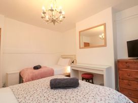 A bedroom with two beds and a television at Saints Cottage in Scarborough