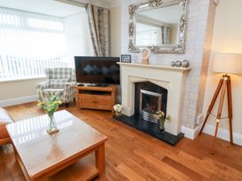A living room with a television and a fireplace at Beach Cove View in Newbiggin-by-the-Sea