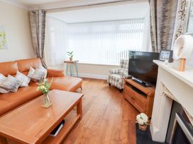 A living room with a sofa and a television at Beach Cove View in Newbiggin-by-the-Sea