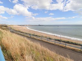 A beach view with a path and grass at Beach Cove View in Newbiggin-by-the-Sea