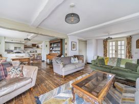 A living room with sofas, a coffee table and a dining table at Spring Park Farmhouse in Launceston