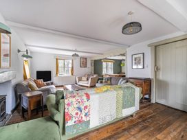 A living room with a sofa, armchair, and table at Spring Park Farmhouse in Launceston