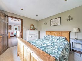 A bedroom with a bed, dresser, and lamp at Spring Park Farmhouse in Launceston