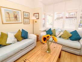 A living room with sofas and wall art at 32 Cranleigh Close Tuckton