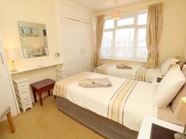 A bedroom with two beds and a mirror at 32 Cranleigh Close Tuckton