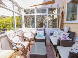 A conservatory with seating and a glass table at 32 Cranleigh Close Tuckton