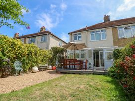 A garden with a table and chairs under an umbrella at 32 Cranleigh Close Tuckton